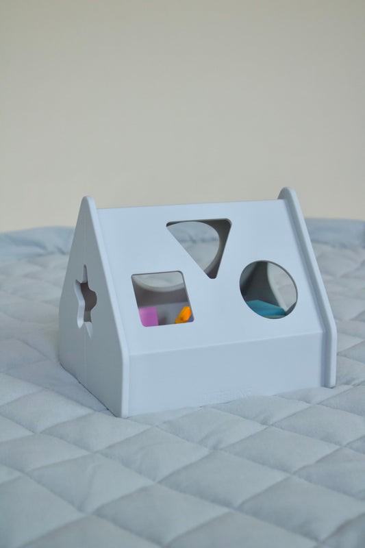 Puffling the sorting house, shape sorting toy, shape sorter toy, developmental toddler toy, developmental baby toy, learning toy, neutral baby toy, neutral toddler toy, mushie toy, mushie shape sorter, front view