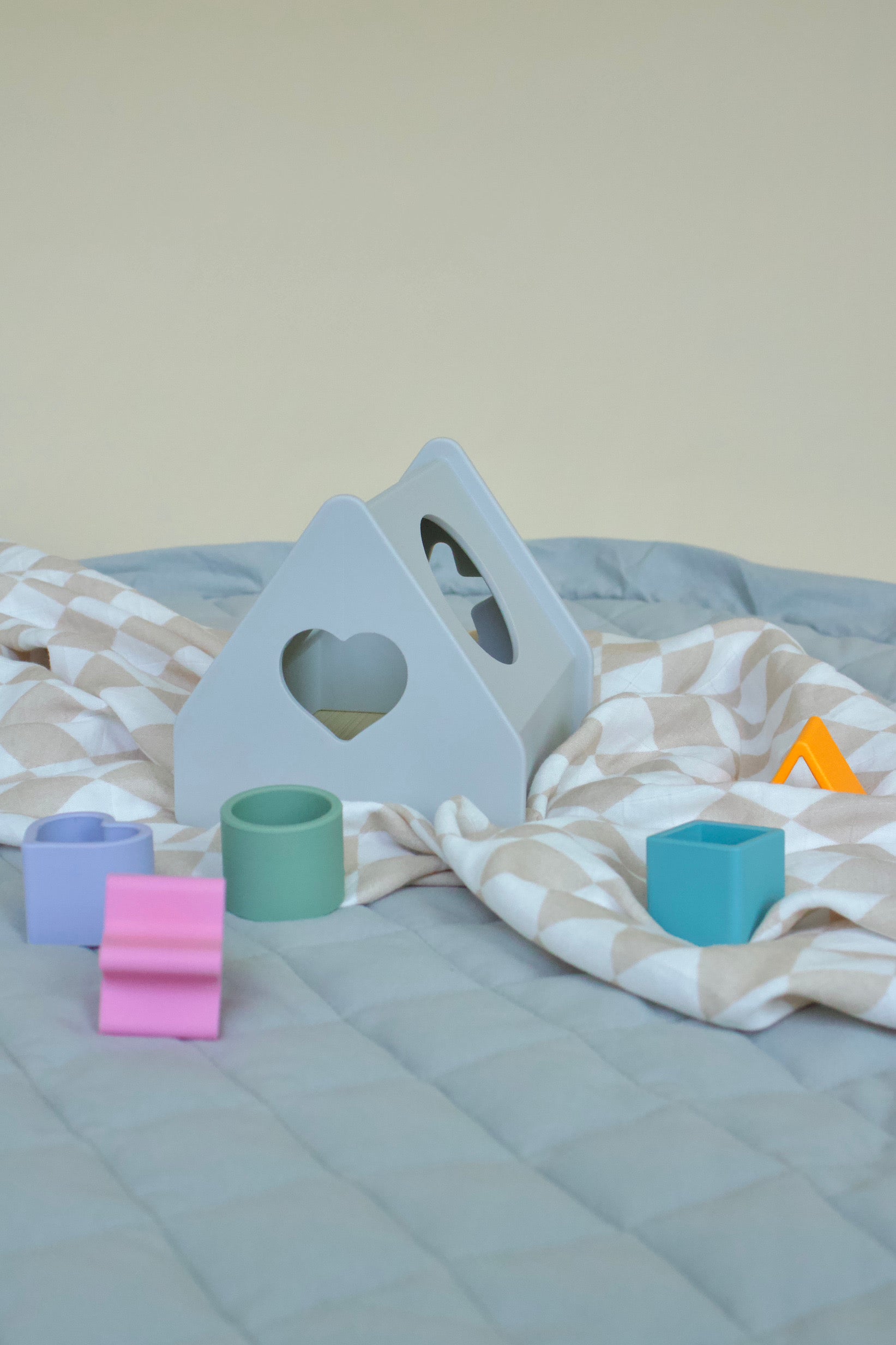 Puffling the sorting house, shape sorting toy, shape sorter toy, developmental toddler toy, silicone nontoxic toy, developmental baby toy, learning toy, neutral baby toy, neutral toddler toy, mushie toy, mushie shape sorter, sitting on swaddle